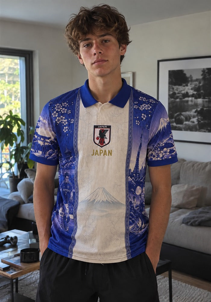 Adolescent portant le maillot du Japon Fujisan dans un salon, bande crème centrale, col polo bleu, écusson JFA avec JAPAN en doré et motifs d'estampe indigo sur les flancs