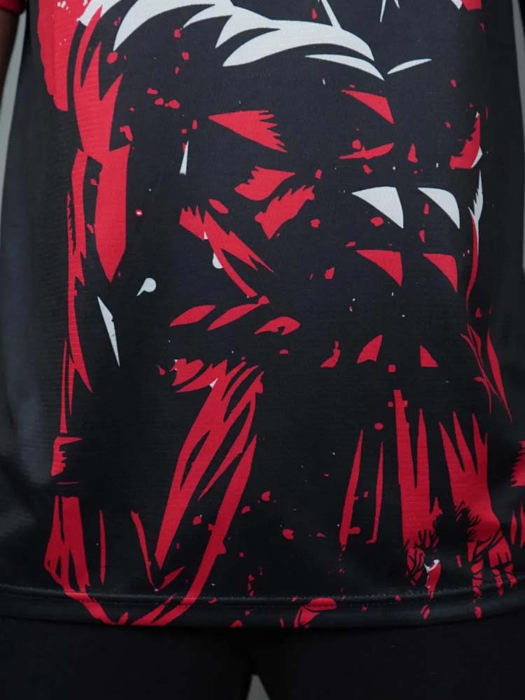 Zoom sur le bas du maillot Japon x Dragon Ball noir, montrant les détails du dessin de Goku en rouge.