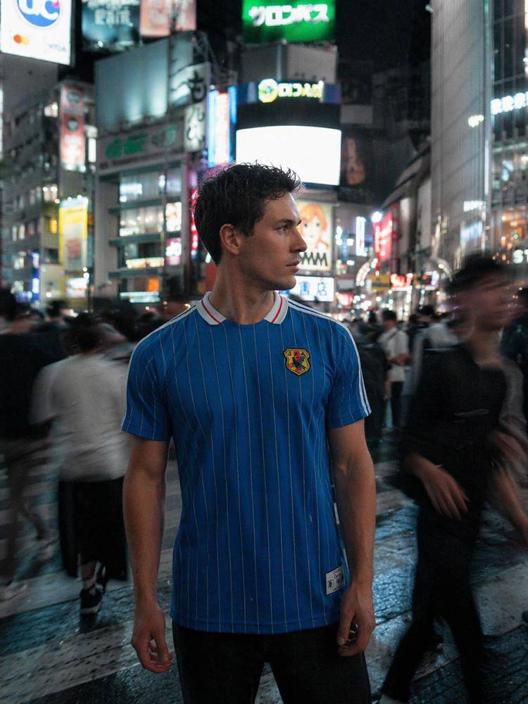 Maillot du Japon Vintage porté par un homme au carrefour de Shibuya la nuit, Tokyo en arrière-plan