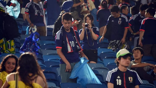 Supporter japonais nettoyant les tribunes après un match de football