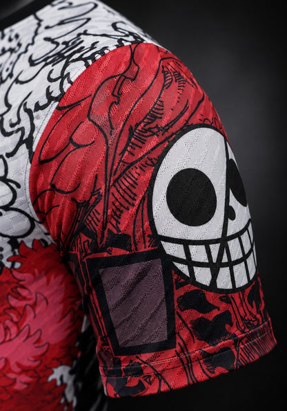Détail de la manche du maillot du Japon Doflamingo One Piece : jolly roger grimaçant sur fond rouge, traits de manga noirs et texture du tissu