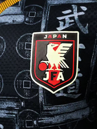 Zoom sur l'écusson JFA brodé du maillot Japon noir kanji Bushido, détail relief