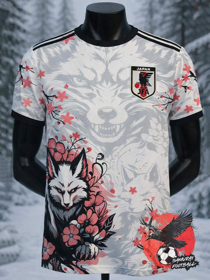 Face avant du maillot du Japon avec un loup blanc dans la neige entouré de sakuras